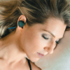 woman wearing bedphones in her bed.