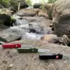 The Out the Front Bottle Opener by Flipped Tools comes in three distinguished colors. All three are lined up on top of a large rock, in the outdoors somewhere.