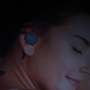 women wearing bedphones while happily sleeping, or perhaps resting her eyes.