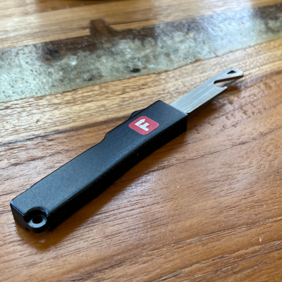 Flipped Tools out the front bottle opener, sporting its small form factor, on a wooden table.