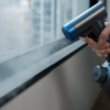 The SUMJet Cordless Dry Cleaner cleaning a window sill.