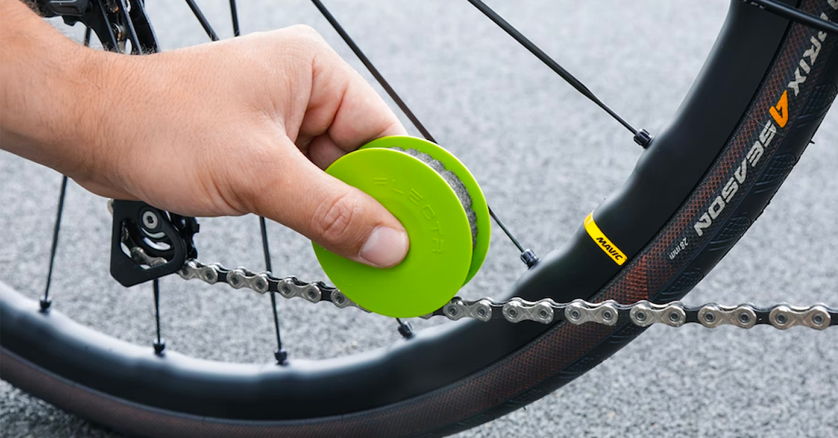 Green disc bike chain care tool lubricating a chain with just a swipe.
